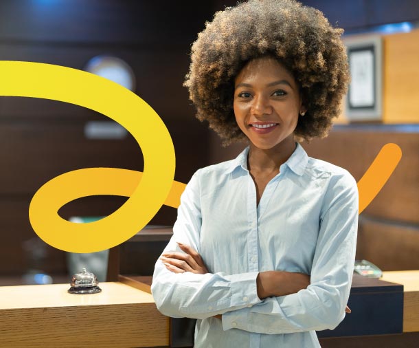 Mulher negra de braços cruzados e sorrindo